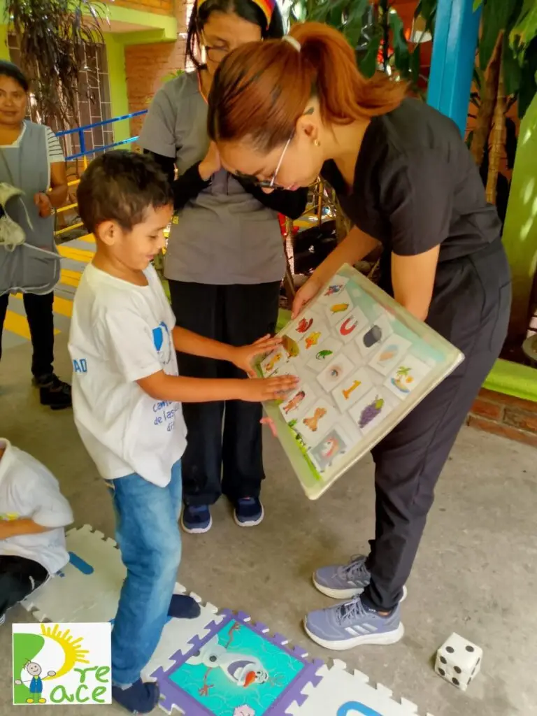 Señorita enseñandole a un niño alternativas de comunicación